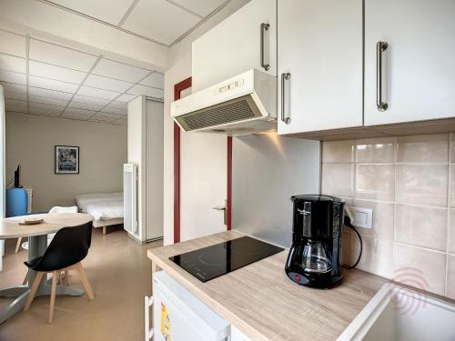 une cuisine avec un mixeur sur un comptoir avec une table dans l'établissement Charmant Studio en Centre-Ville, Proche Thermes avec Balcons et Wifi – Animaux Acceptés - FR-1-451-177, à Lamalou-les-Bains