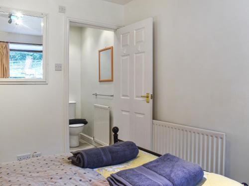 a bedroom with a bed and a bathroom with a toilet at The Byre in Ingleby