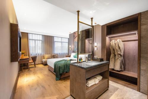 a hotel room with a bed and a bathroom at Yiwu Manxin Hotel in Yiwu