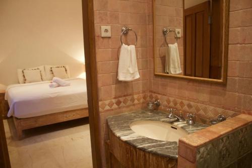 チャンディダサにあるVilla Hanoman Candidasa - 3 Bedrooms With Private Poolの洗面台とベッドのあるバスルーム