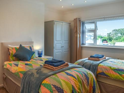 a bedroom with two beds and a window at Wylandre in Amlwch