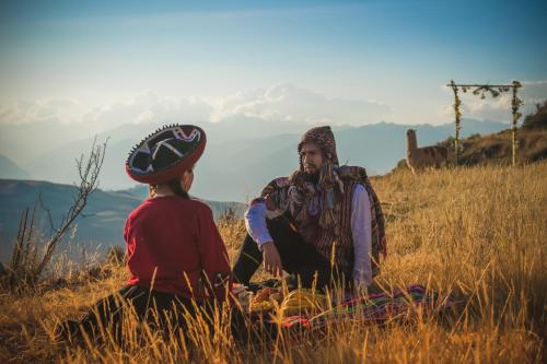 two people sitting in a field of tall grass at Sky Dome Peru in Cusco