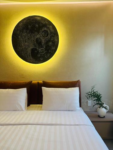 a bedroom with a bed with a moon on the wall at Phuong Nam Hotel An Giang in Long Xuyên