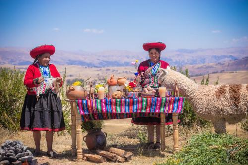 dos mujeres frente a una mesa con un camello en Sky Dome Peru, en Cusco