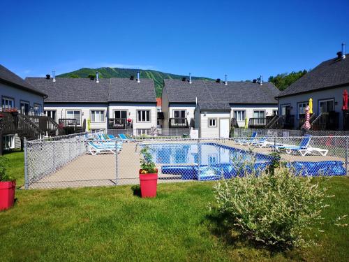 uma piscina num quintal com casas em Les Condos de la Montagne 2 em Beaupré