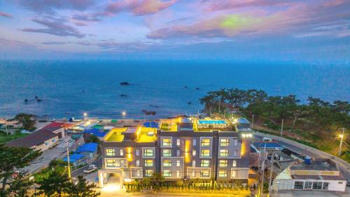 a large building with the ocean in the background at Beachhill Pool Villa in Gyeongju