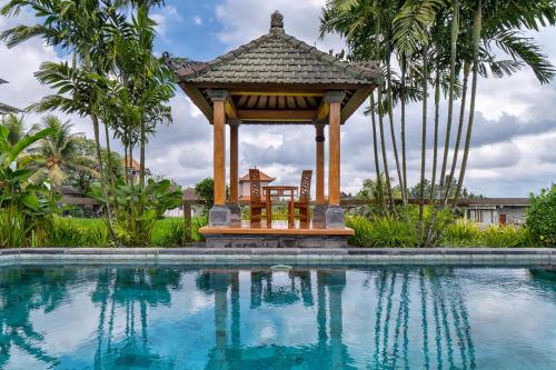 a gazebo next to a swimming pool at Cahaya Ubud Villa in Ubud