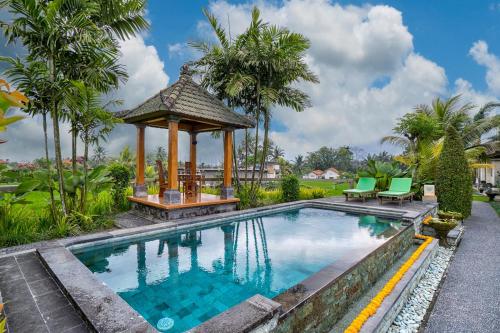 a swimming pool with a gazebo next to a house at Cahaya Ubud Villa in Ubud