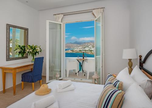 a bedroom with a bed with a view of the ocean at Cape Mykonos in Mýkonos City