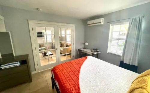 a bedroom with a bed and a large window at The Agustin Guesthouse - Men Only Clothing Optional in Fort Lauderdale