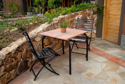 una mesa de madera y 2 sillas en el patio en Fleur Lodge, en Carhuaz