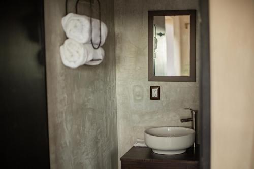 bagno con lavandino, specchio e asciugamani di Gardenia Collective a Tulum