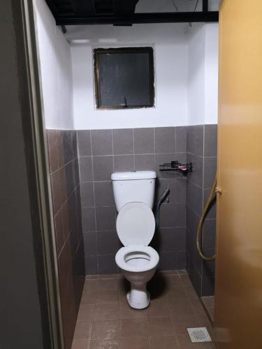 een badkamer met een wit toilet in een stal bij Bilik Bajet BDS in Temerloh