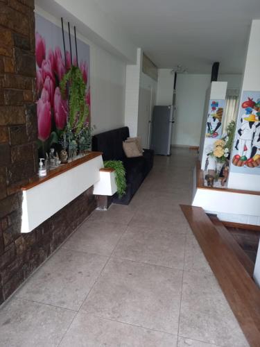 ein Wohnzimmer mit Sofa und Blumen an der Wand in der Unterkunft Departamento en Pueblo Libre in Lima