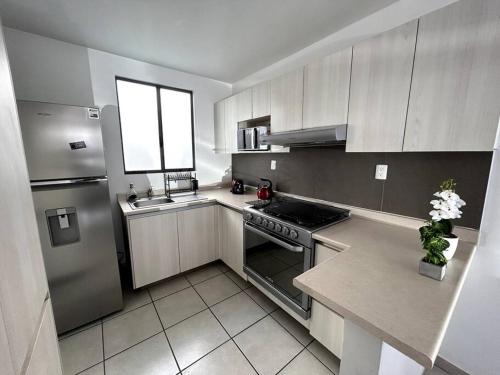 a kitchen with stainless steel appliances and a window at Casa completa en condominio privado con alberca in Miranda