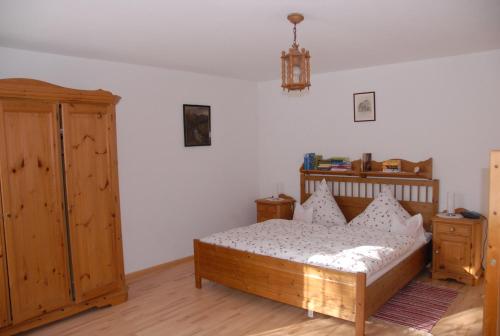 a bedroom with a wooden bed and a wooden cabinet at Waldhofalm Angerer in Berchtesgaden