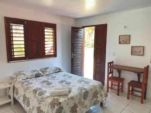a bedroom with a bed and a table and a desk at Pousada Recanto dos Parente - Icaraizinho de Amontada in Amontada