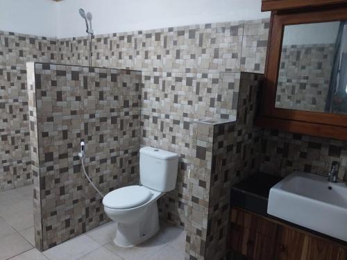 a bathroom with a toilet and a sink at Banana Leaf Resort in Gili Trawangan