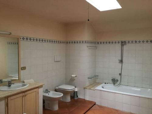 een badkamer met een bad, een toilet en een wastafel bij Court of Artist Friuli in Sedegliano