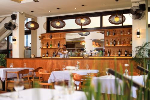 a woman standing behind the bar of a restaurant at Amadea Resort & Villas Seminyak Bali in Seminyak