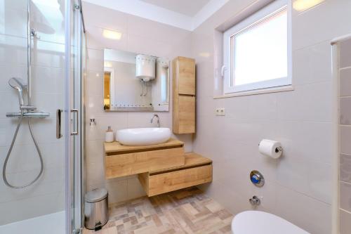 a bathroom with a sink and a toilet and a mirror at Apartments with a parking space Mali Losinj (Losinj) - 15201 in Mali Lošinj