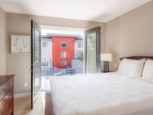 a bedroom with a bed and a sliding glass door at Breakaway Beach Villa near Lake in Penticton