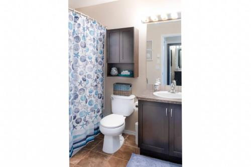 a bathroom with a toilet and a sink at Breezy Beach Villa near the Lake in Penticton