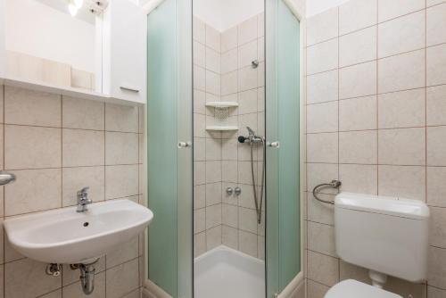 La salle de bains est pourvue d'un lavabo, de toilettes et d'une douche. dans l'établissement Apartment Kraljevica 17589b, à Kraljevica