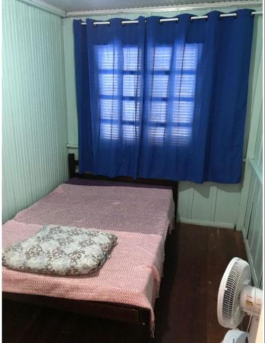 a room with two beds and a blue curtain at Casa praia da cal in Torres