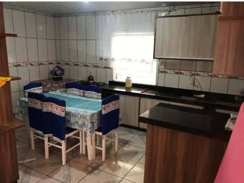 a kitchen with a table and chairs in it at Casa praia da cal in Torres