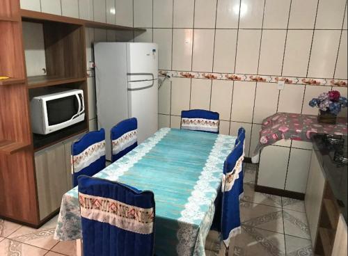 a kitchen with a table and chairs and a refrigerator at Casa praia da cal in Torres