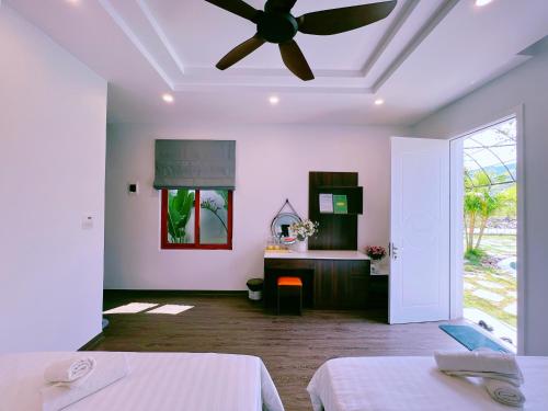 een slaapkamer met 2 bedden en een plafondventilator bij Lagom Ninh Bình Homestay in Ninh Binh