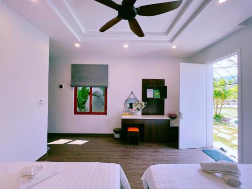 a bedroom with two beds and a ceiling fan at Lagom Ninh Bình Homestay in Ninh Binh