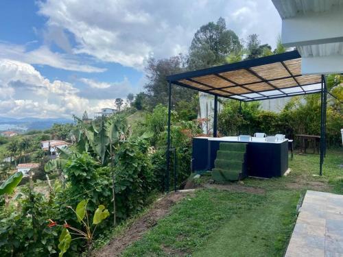 a table and chairs under a canopy in a garden at BERAKHAH SPA & ROOMS in Guatapé