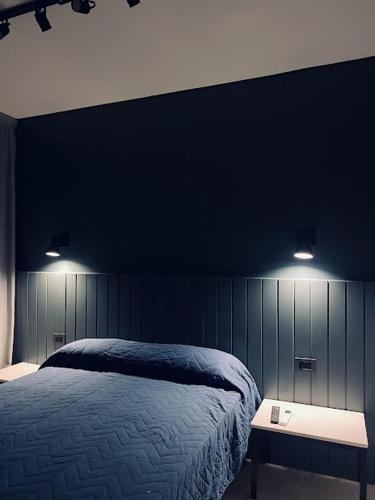 a bedroom with a bed and two lights on the wall at BACO at HOME in Corrientes