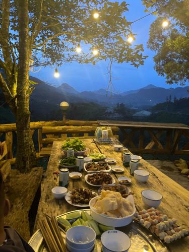 a table with plates of food on it with a view at Pea homestay in Sa Pa