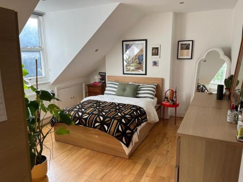 a bedroom with a bed with pillows on it at 2 bedroom top floor flat, West Dulwich in London