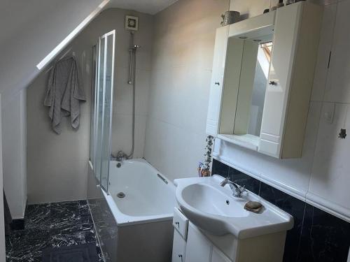 a white bathroom with a sink and a mirror at 2 bedroom top floor flat, West Dulwich in London