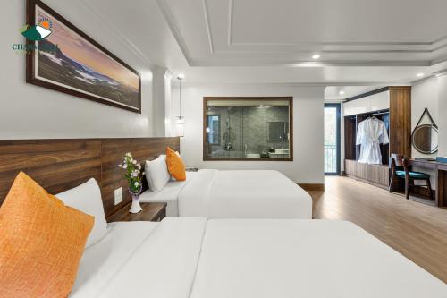 um quarto de hotel com duas camas e uma secretária em Charm Hill Sapa Hotel em Sa Pa
