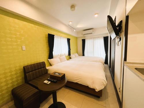 ein Hotelzimmer mit einem Bett und einem Stuhl in der Unterkunft BiBi Hotel FUTENMA in Ginowan