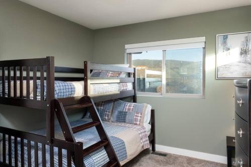 a bedroom with two bunk beds and a window at Sun & Sails Villa by the Beach in Penticton