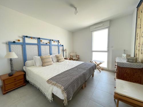 une chambre avec un grand lit avec une tête de lit bleue dans l'établissement Appartement Neuf 3/4 Couchages à 30m de la Plage avec Parking - FR-1-364-161, à Saint-Brévin-les-Pins