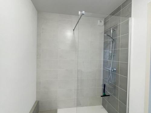 une douche avec une porte vitrée dans une salle de bain dans l'établissement Appartement Neuf 3/4 Couchages à 30m de la Plage avec Parking - FR-1-364-161, à Saint-Brévin-les-Pins