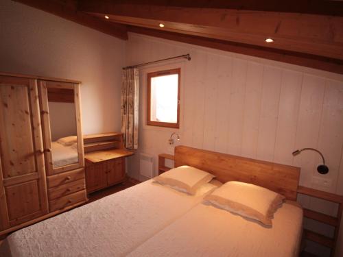 une chambre avec un grand lit et un miroir dans l'établissement Chalet 5 pièces, 10 pers, 97m², Les Saisies - Hauteluce, proche pistes et commerces - FR-1-293-325, à Hauteluce