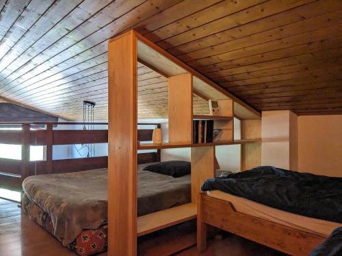 Cette chambre comprend 2 lits superposés et un plafond en bois. dans l'établissement Duplex cosy 6 pers avec 2 balcons & parking à La Clusaz - FR-1-459-214, à La Clusaz