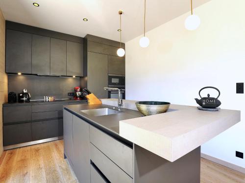 une cuisine avec des armoires noires et un comptoir dans l'établissement Chalet de luxe skis aux pieds avec SPA - Courchevel - FR-1-575-192, à Courchevel