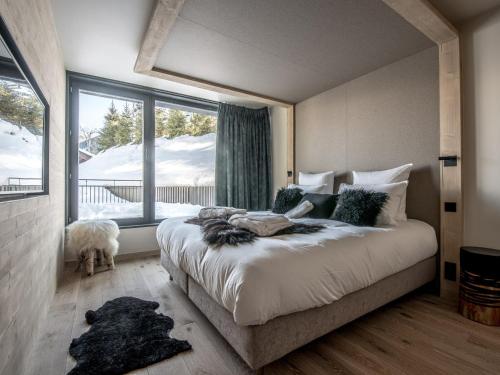 une chambre avec un grand lit et une fenêtre dans l'établissement Chalet de luxe skis aux pieds avec SPA - Courchevel - FR-1-575-192, à Courchevel