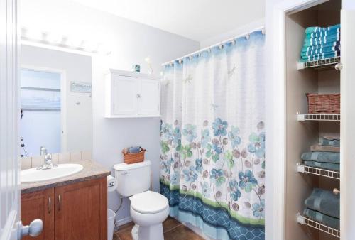 a bathroom with a toilet and a shower curtain at Sunshine & Sand Villa near Beach in Penticton