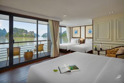 een hotelkamer met een bed en een groot raam bij Halong Capella Cruise in Ha Long