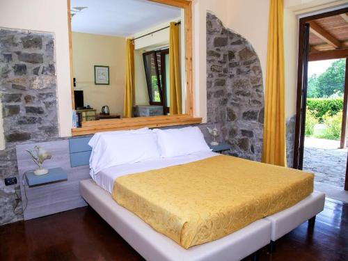 1 dormitorio con 1 cama grande y pared de piedra en Property in Trivigno PZ, en Trivigno